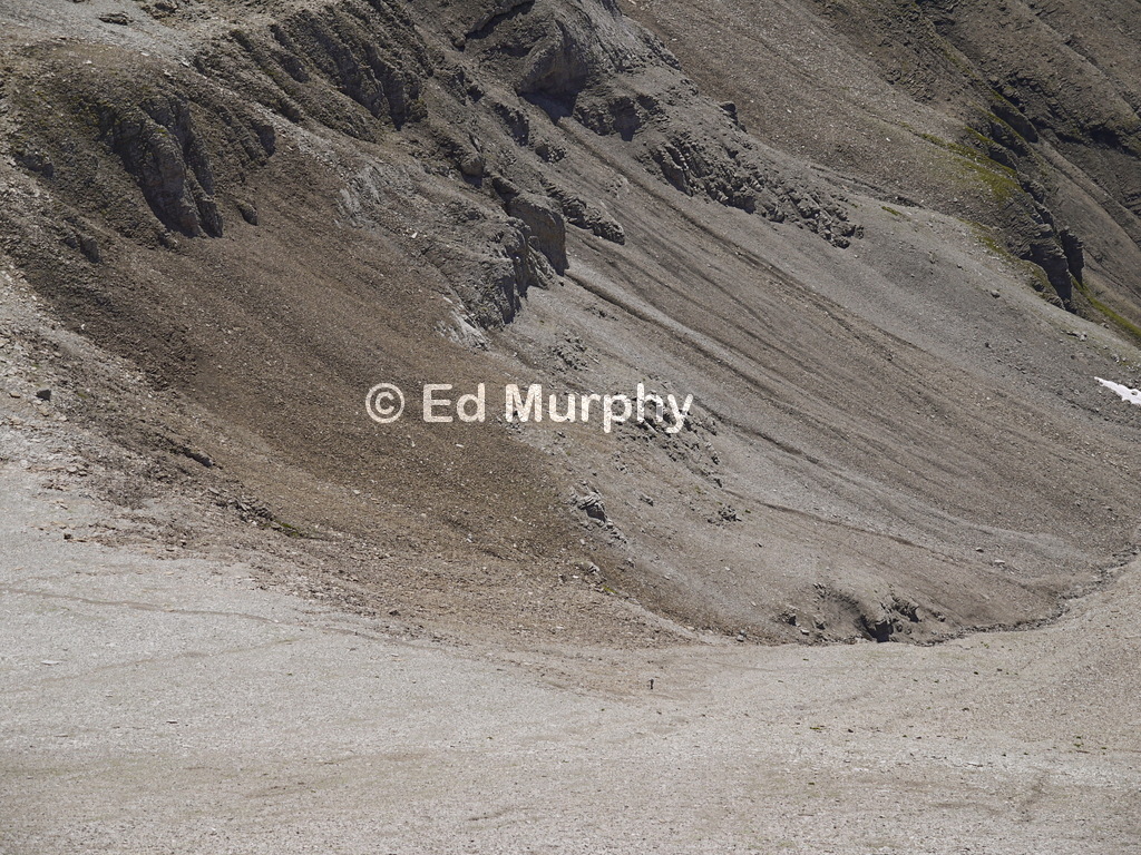 A lone walker approaches the stony saddle between the Schwalmeren and the Hoganthorn